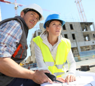 Engineers on building site checking plans